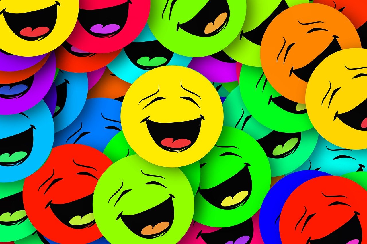 An assortment of different colored "laughing" emojis.