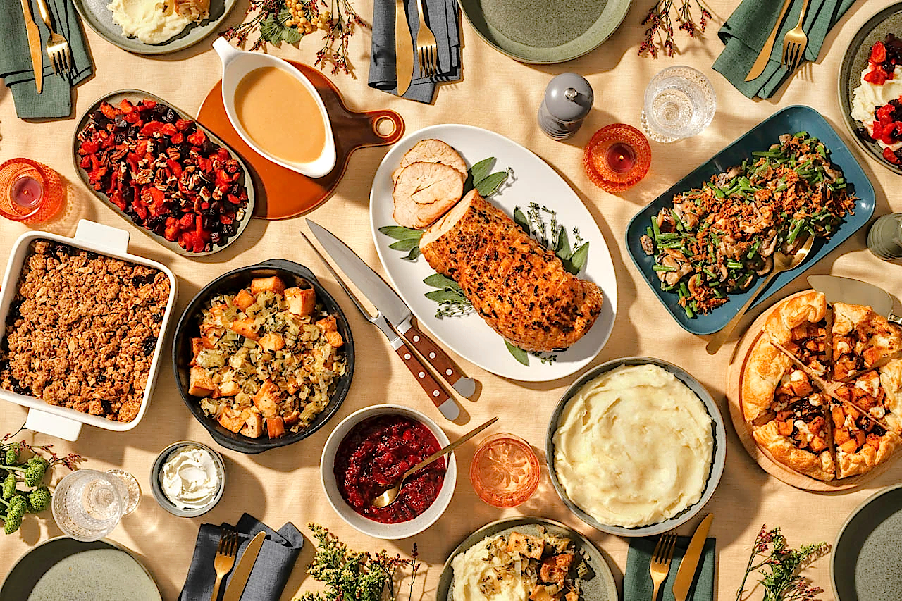 Overhead photo of a Thanksgiving buffet with a wide assortment of traditional American Thanksgiving dishes.