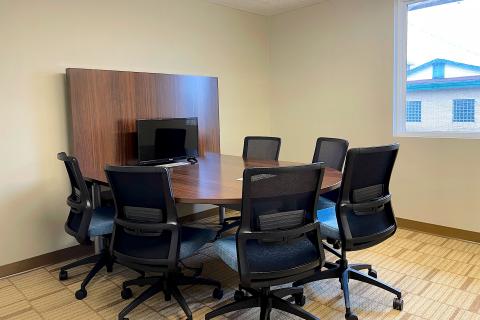 A room with a horseshoe table and six rolling task chairs