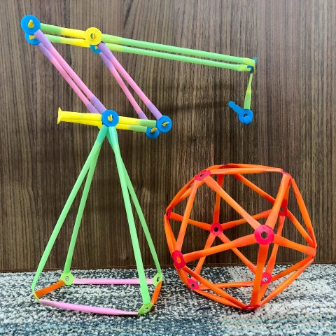 A crane and a large ball constructed with Strawbees building toys.