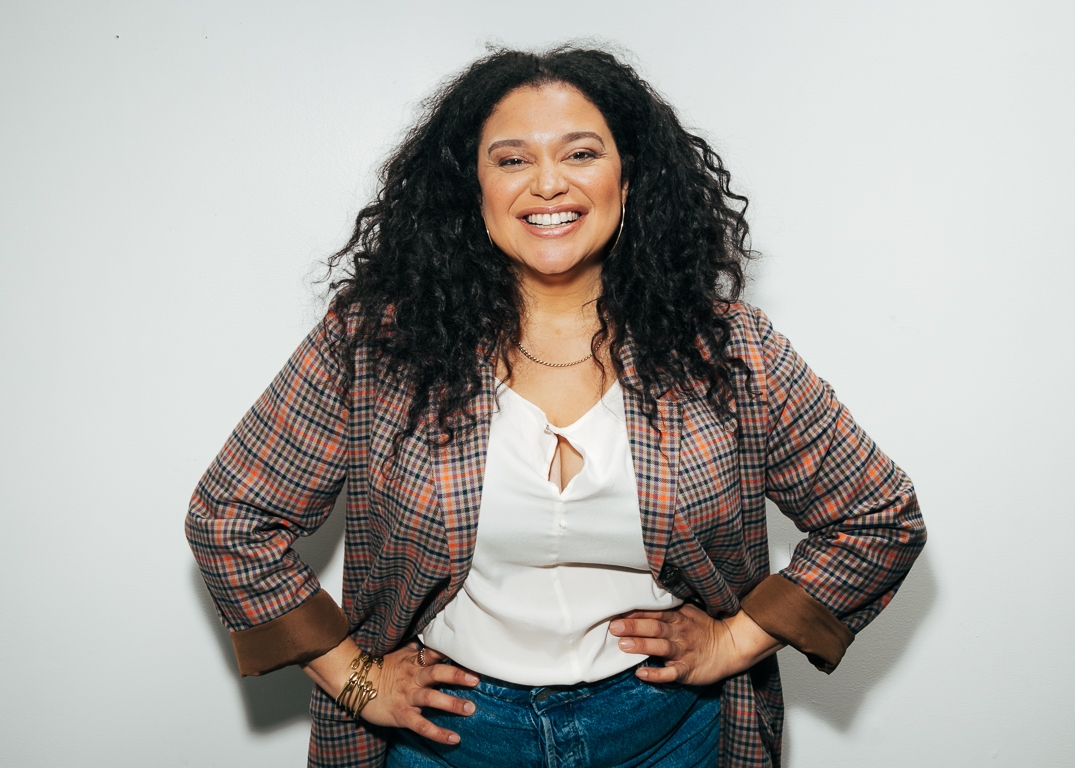 A smiling woman with her hands on her hips.