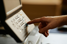 Hand pressing buttons on a copier machine